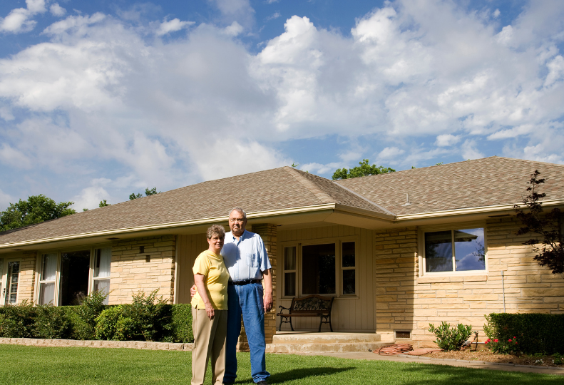 Older couple in front of their home