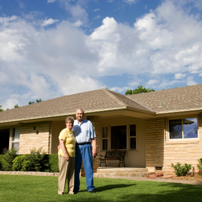 Older couple in front of their home