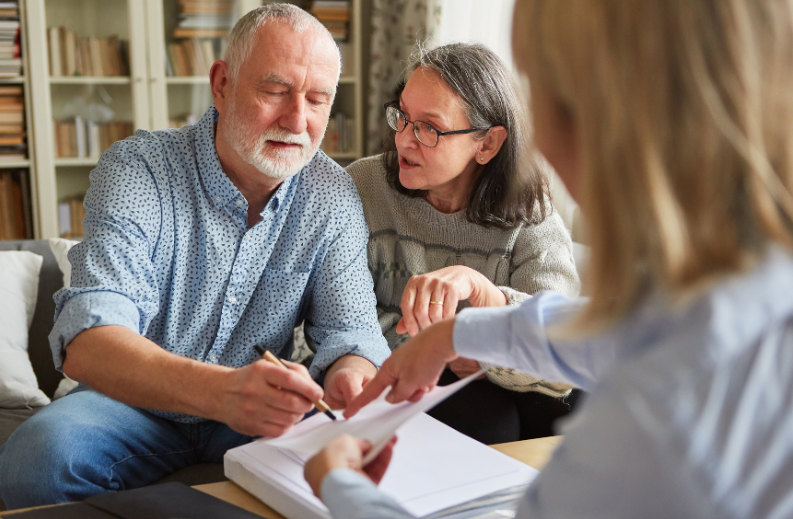 couple signing durable power of attorney document with attorney