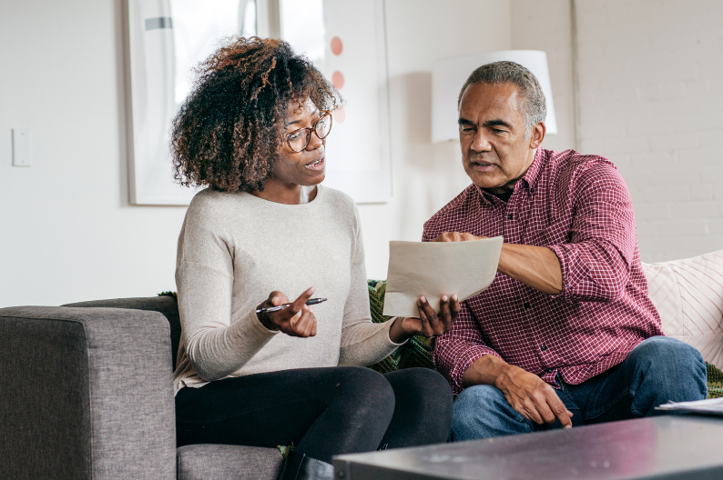 father and adult daughter looking at estate planning documents